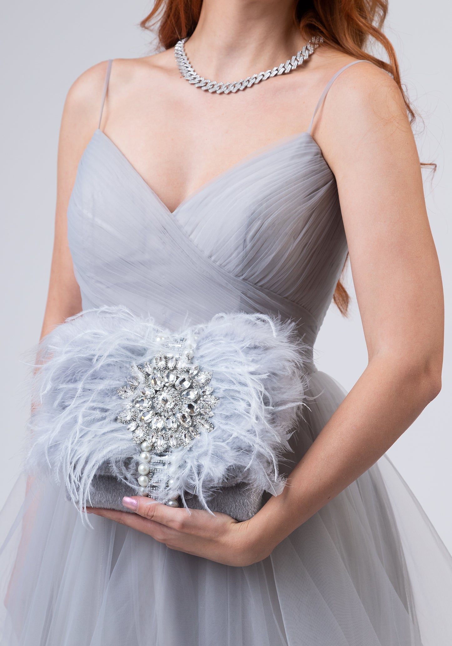Grey luxury handbag with gemstones and feathers